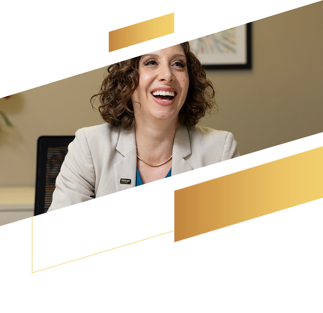 Smiling woman with curly hair in a light blazer sits at a desk, gold geometric shapes overlayed, capturing the confident energy of investment management.