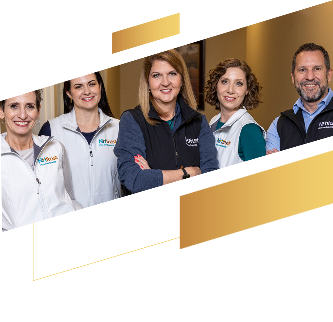 Five people in NTrust branded vests stand together, smiling at the camera in an office setting, showcasing their commitment to supporting nonprofits.